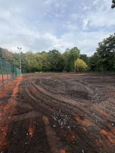 Die abgetragenen Plätze P4 bis P6 mit Fahrspuren im Untergrund, dahinter die Baumreihe